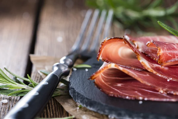 Porción de jamón en rodajas sobre plato negro —  Fotos de Stock