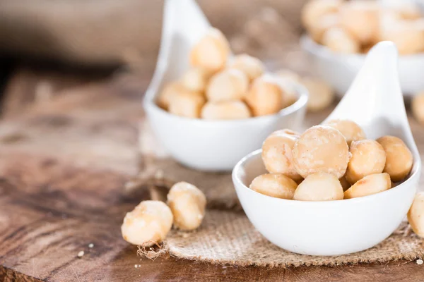 Cuchara de madera con nueces de macadamia — Foto de Stock