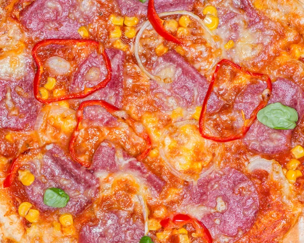Pizza z salami z bazylią jako tło — Zdjęcie stockowe
