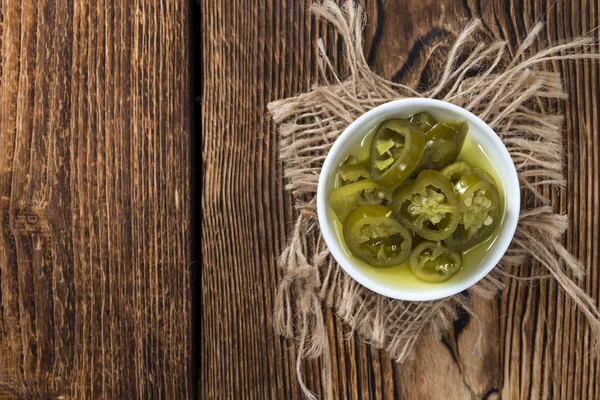 Jalapeňos na dřevěné pozadí — Stock fotografie