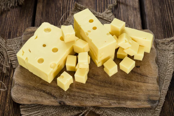 Nakrájený sýr na dřevěné desce — Stock fotografie