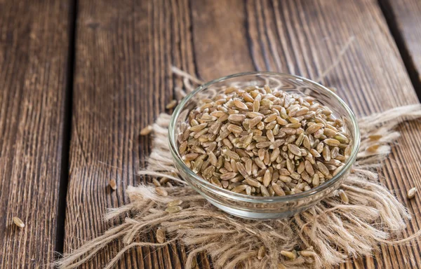 Ciotola con farro su fondo di legno — Foto Stock