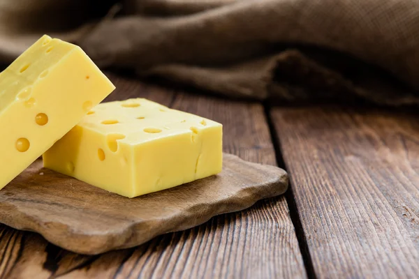 Fából készült táblán kockára vágott sajt — Stock Fotó