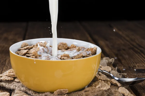 Derramando leite em uma tigela com flocos de milho — Fotografia de Stock