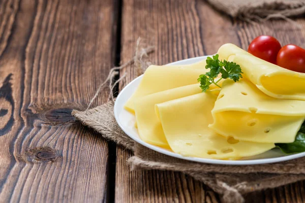 Нарезанный сыр на деревянном фоне — стоковое фото
