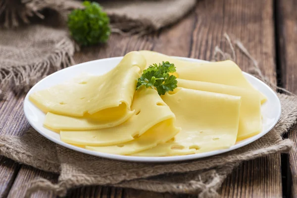 Queso en rodajas sobre fondo rústico de madera — Foto de Stock