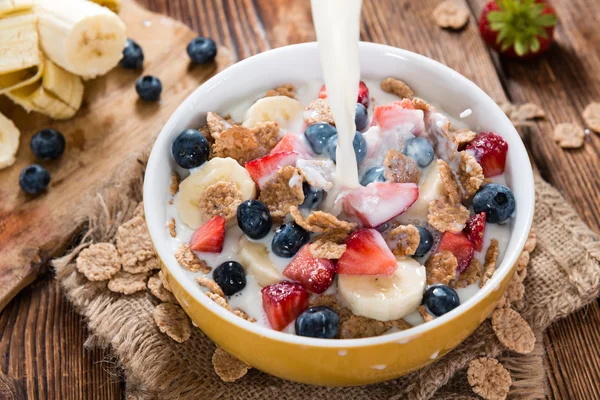 Pouring Milk in a bowl with Cornflakes and Fruits — Stock Photo, Image