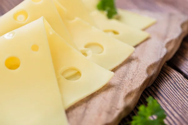 Ahşap arka plan üzerine peyniri dilimlenmiş — Stok fotoğraf