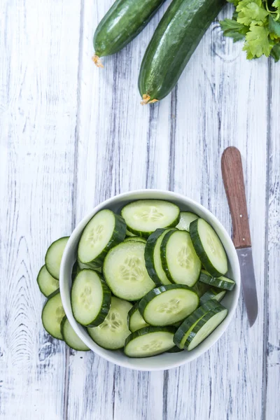 Gurkenscheiben auf einem alten Holztisch — Stockfoto