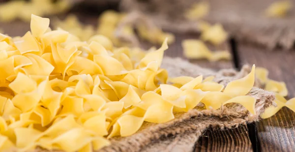 Raw Tagliatelle on rustic wooden background — Stock Photo, Image