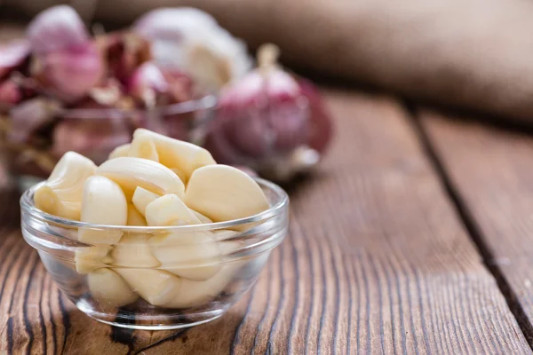 Geschälter Knoblauch auf rustikalem Holzgrund — Stockfoto