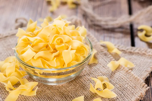 Raw Tagliatelle on rustic wooden background — Stock Photo, Image