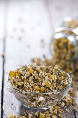 Dried Camomile  on rustic wooden background clipart