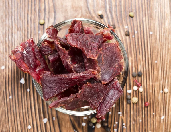 Beef Jerky on wooden background — Stock Photo, Image