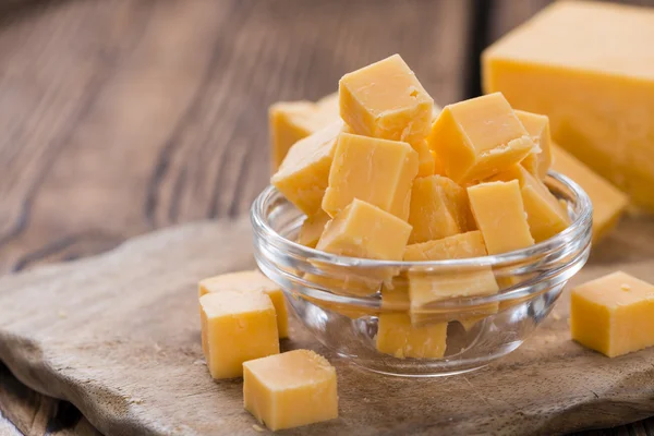 Cheddar picado sobre fondo de madera — Foto de Stock