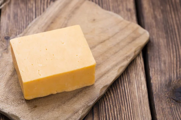 Diced Cheddar on wooden background — Stock Photo, Image