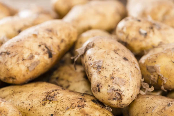 Gedeelte van aardappelen op een donkere houten achtergrond — Stockfoto