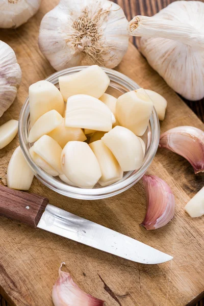 Aglio sbucciato su sfondo di legno — Foto Stock