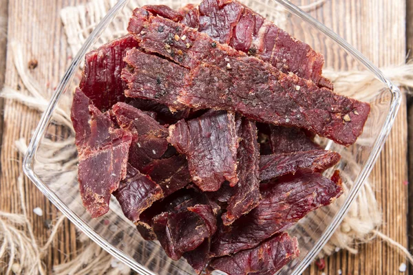 Carne Jerky sobre fondo de madera — Foto de Stock