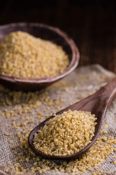 Bulgur cru (em fundo de madeira ) — Fotografia de Stock