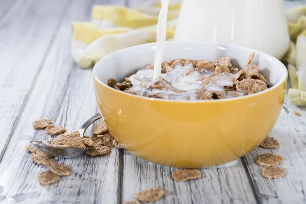 Derramando leite em uma tigela com flocos de milho — Fotografia de Stock