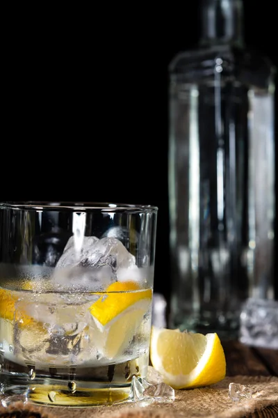 Vodka in glass with lemons and ice — Stock Photo, Image