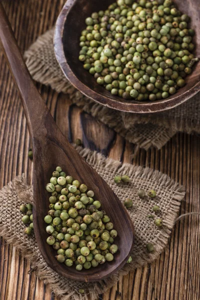 Grãos de pimenta na mesa de madeira — Fotografia de Stock