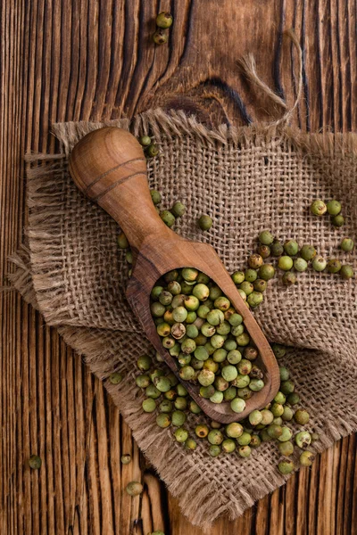 stock image Peppercorns on wooden table