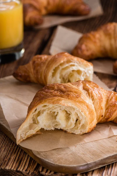 Croissant a fa asztalon — Stock Fotó