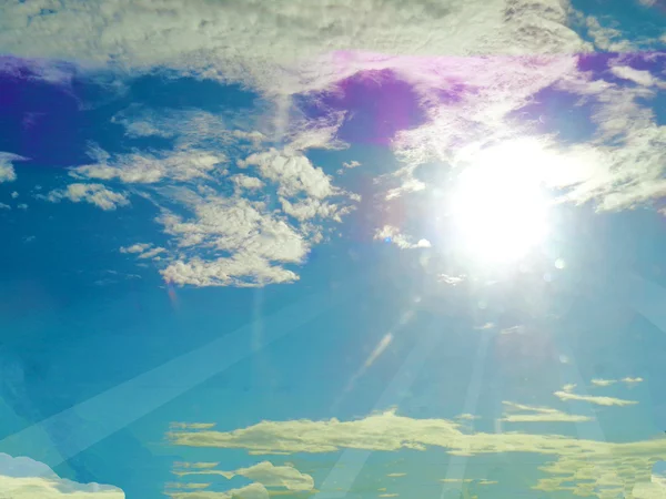 Slunečních paprsků na modrou oblohu s mraky na pozadí — Stock fotografie