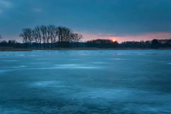 Lago congelado, árvores e céu noturno com pôr-do-sol — Fotografia de Stock