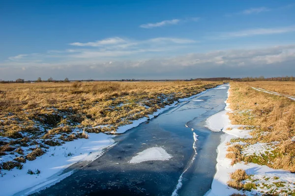 Frozen river and dry meadows, view on winter day — Foto de Stock
