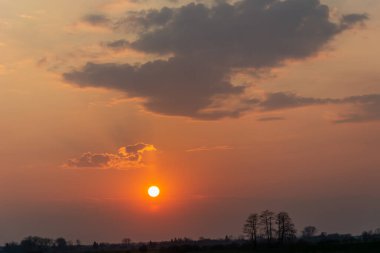 Yuvarlak güneş ve bulutlu puslu pembe gökyüzü