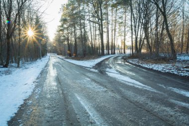 A fork in the road, snow-covered and icy, with the glow of the setting sun, Stankow, Lubelskie, Poland