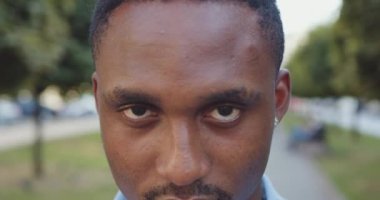 Şehir arka sokaklarında yeşil ağaçlı kameralara poz veren, konsantre olmuş, Afro-Amerikan gençlerinin ön görüntüsü.