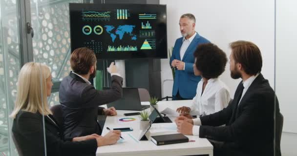 Geschäftskonzept, bei dem gut aussehende erfolgreiche, selbstbewusste und vielfältige Teams von Männern und Frauen bei der Analyse von Infografiken auf digitalem Whiteboard während einer gemeinsamen Sitzung im Sitzungssaal — Stockvideo