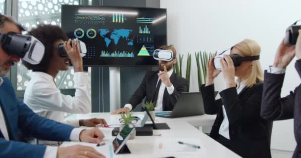 Előnézet a jól kinéző sikeres tapasztalt különböző korú vegyes verseny üzleti partnerek, amelyek együtt dolgoznak speciális 3D-s szemüveg konferenciateremben — Stock videók