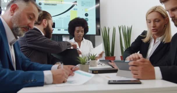 Närbild av attraktiv säker målmedveten framgångsrik blandras affärskollegor som arbetar tillsammans i konferensrum över affärsstrategi för företaget — Stockvideo