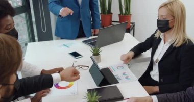 İyi görünümlü başarılı iş ortaklarının el hareketlerini yakından takip edin. Yüzlerine maske takan başarılı iş ortakları. Covid-19 pandemisi sırasında yumruk tokuşturmak dostluk göstergesiydi.