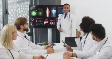 Çekici, başarılı, deneyimli, siyah tenli bir doktorun, uluslararası attantif meslektaşlarının önünde insan iç yapısını sunması.