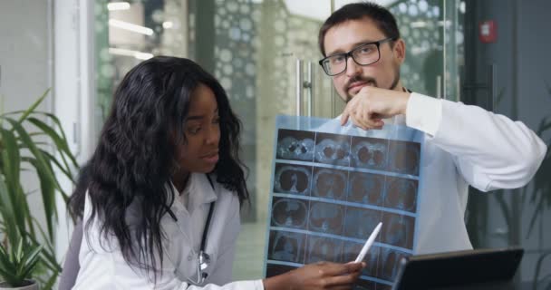 Tıbbi konsept, iki güvenilir bilge çok ırklı doktorun çevrimiçi konferans düzenlemesi ve röntgen görüntülerinin sonuçlarını analiz etmesi. — Stok video