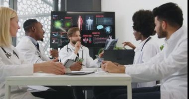 Hastaların röntgen taramasını kullanarak tedavi yöntemleri hakkında aralarında danışmanlık yapan iyi görünümlü, zeki ve başarılı bir doktor takımı.