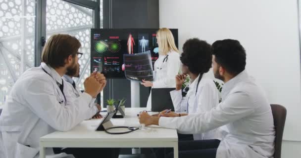 Dobře vypadající sebevědomá zkušená lékařka pořádající prezentaci na digitální tabuli na téma vnitřních lidských orgánů, které postihují kardiovaskulární onemocnění před multiraciálními — Stock video