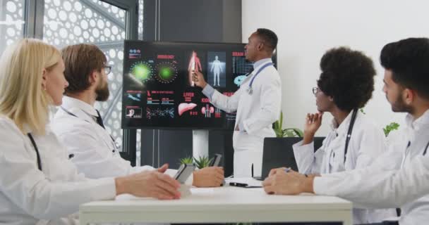 Knap hoog opgeleide succesvolle zwarte arts eindigt zijn digitale presentatie over interne menselijke organen thema en verheugen zich over het applaus van zijn multiraciale tevreden collega 's, close-up — Stockvideo
