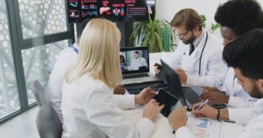 Online konferans sırasında kadın başhekimle birlikte çalışan başarılı, çok ırklı tıp çalışanlarının portresi.