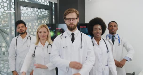 Portret van goed uitziende postieve tevreden succesvolle gecvalideerde internationale team van medische collega 's die poseren op camera met gekruiste armen — Stockvideo