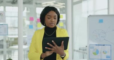 Modern ofis odasındaki tablet bilgisayarında çalışan oldukça yoğun profesyonel, yüksek kalifiye Afro-Amerikan kadınlarına yakın durun.