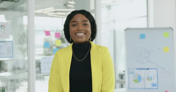 Gut aussehende lächelnde selbstbewusste erfolgreiche schwarzhäutige Geschäftsfrau in stylischer Kleidung, die inmitten eines modernen Büroraums vor der Kamera steht — Stockvideo