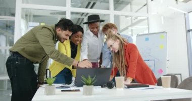 İyi görünümlü, duygusal, neşeli, başarılı, yetenekli, çeşitli takımların ön görüntüsü dizüstü bilgisayarda iyi haberler aldılar ve ortak projeyi bitirdikten sonra zaferi kutladılar.