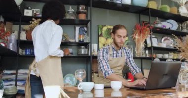 Küçük bir hediyelik eşya dükkanında birlikte çalışan, çalışkan, karma ırk satıcılarının portresi.